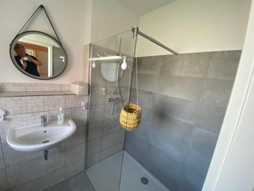 ein Bad mit einer Dusche, einem Waschbecken und einem Spiegel in der Unterkunft Schönes Wohnen im Wendland in Dannenberg
