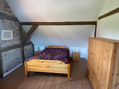 ein Schlafzimmer mit einem Holzbett im Dachgeschoss in der Unterkunft Schönes Wohnen im Wendland in Dannenberg