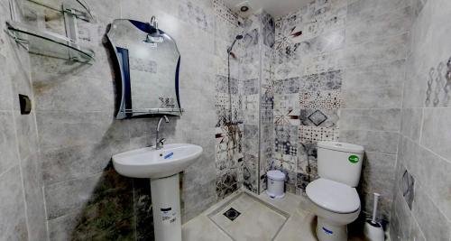 uma casa de banho com um WC branco e um lavatório. em KHALIJ HOSPITALITE em Dakhla