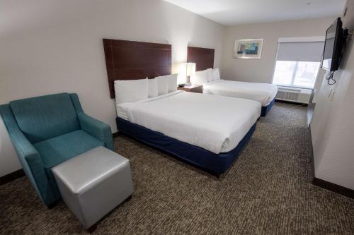 ein Hotelzimmer mit 2 Betten und einem Stuhl in der Unterkunft Best Western Plus Lafayette Vermilion River Inn & Suites in Lafayette