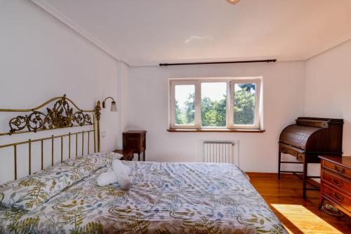 een slaapkamer met een bed en een piano bij Casona con gran jardín in Camargo