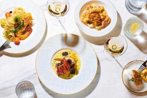 a table with plates of food and glasses of wine at JW Marriott Jeju Resort & Spa in Seogwipo