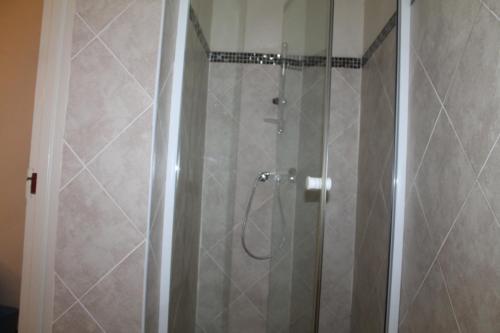 eine Dusche mit Glastür im Bad in der Unterkunft Thokoza guest house in Manzini