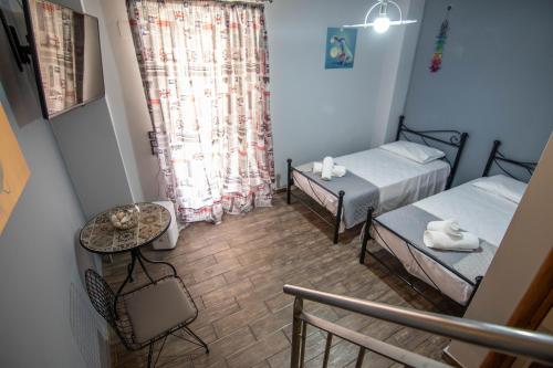 cozy house في Vlikhón: غرفة صغيرة بسريرين وطاولة