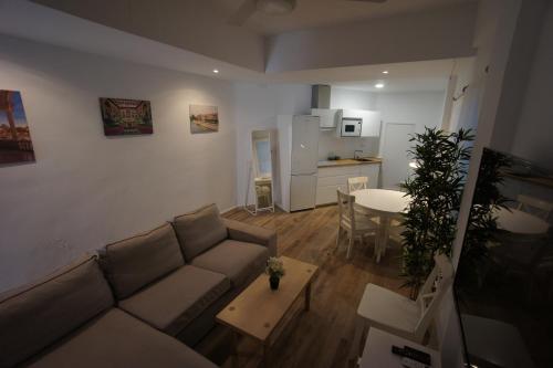 sala de estar con sofá y mesa en RentalSevilla Disfruta por San Leandro en un alojamiento con 3 habitaciones en Sevilla