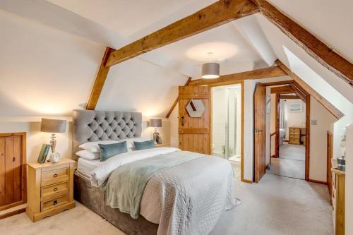 ein Schlafzimmer mit einem großen Bett im Dachgeschoss in der Unterkunft The Woodrow in Cawston