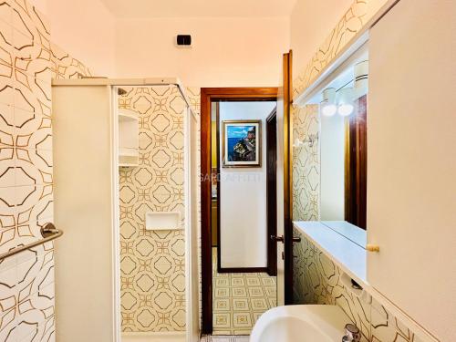 ein Bad mit einem Waschbecken und einem Spiegel in der Unterkunft Flora Apartment - 100 metri dal Lago di Garda - Piscina in Sirmione