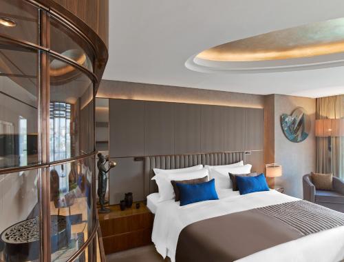 um quarto com uma cama grande e almofadas azuis em The St. Regis Istanbul em Istambul