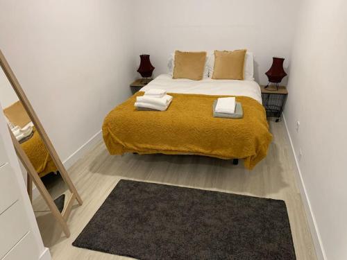 a bedroom with a bed with a yellow blanket at Casa do Til, central Funchal in Funchal