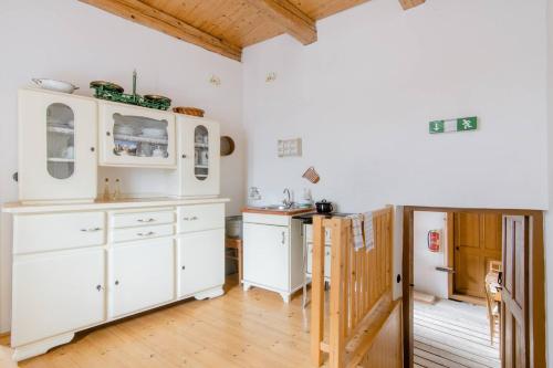 a kitchen with white cabinets and a wooden floor at Vodní mlýn Wesselsky in Odry