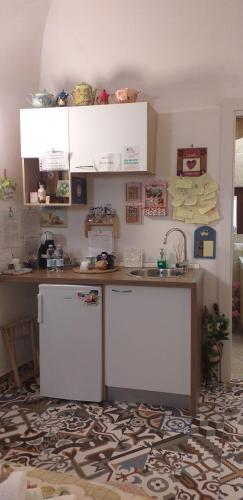 a kitchen with a counter and a sink and a refrigerator at Le camelie in Altamura