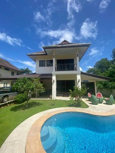 a house with a swimming pool in front of a house at Thai style 3 bedroom pool house. in Khao Lak