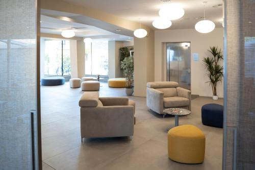 a lobby with couches and chairs in a building at Hotel Malavoglia in Acitrezza