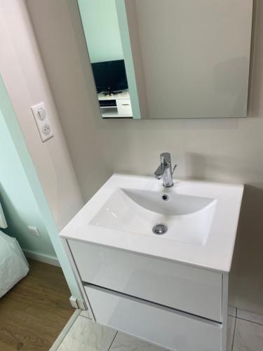 une salle de bain avec un lavabo blanc et un miroir dans l'établissement Chambre moderne 24h du Mans 10 min du circuit SDB privative, à Laigné-en-Belin