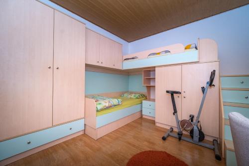 a small bedroom with a bunk bed and two scooters at Spacious apartment 50 m from the beach in Postira