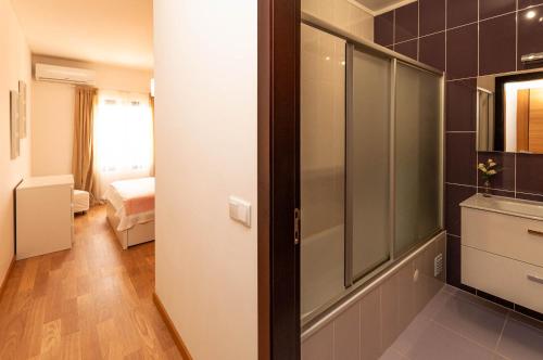 a bathroom with a walk in shower and a bedroom at Almond Apartment by OCvillas in Vale de Pedras