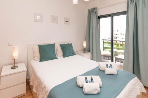 a bedroom with a large bed with towels on it at Almond Apartment by OCvillas in Vale de Pedras