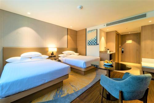 a hotel room with two beds and a table at Courtyard by Marriott Vadodara in Vadodara
