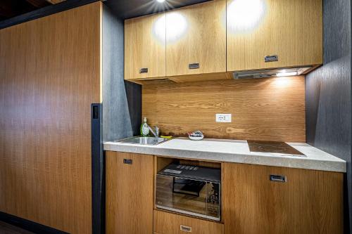 a kitchen with wooden cabinets and a sink at Martelli 6 Suite & Apartments in Florence