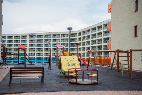 ein leerer Spielplatz mit einem großen Gebäude im Hintergrund in der Unterkunft GAVAS APARTMENTS VIVA City in Cluj-Napoca