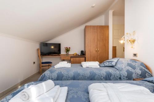 sypialnia z dwoma łóżkami i telewizorem w obiekcie Villa Cassia w miejscowości Mali Lošinj