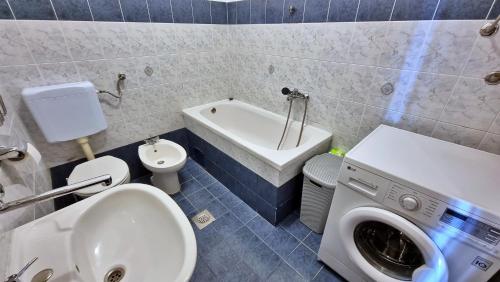 a bathroom with a washing machine next to a toilet at Apartment Gogo Duce in Duće