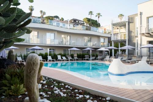 a swimming pool in front of a building at Hotel Malavoglia in Acitrezza