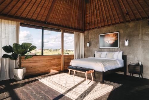 a bedroom with a bed and a large window at Beach 600M - Designer Villas - Perenenean - Private Pool in Canggu