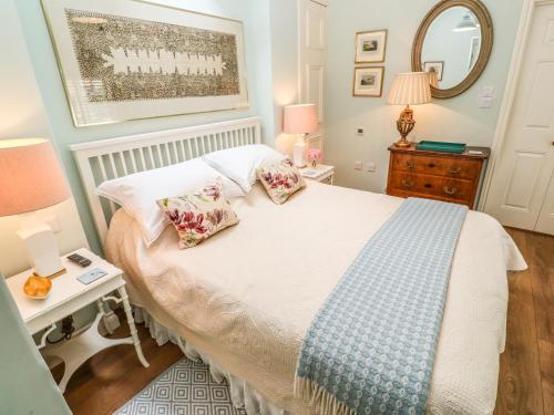 a bedroom with a bed with two pillows on it at The Coach House at Pendower House in Fowey