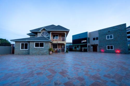 a brick parking lot in front of a building at Bays Lodge, Accra in Accra