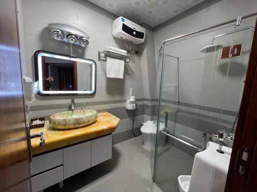 y baño con lavabo y ducha. en Khách sạn Hoàng Yến en Lao Cai