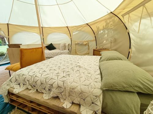 een slaapkamer met een bed in een tent bij Minicamping Kleintje Zandpol 