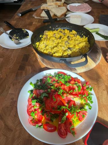 een tafel met borden en een deel van het voedsel bij Wild Hunts Lodge Retezat in Raul Mare