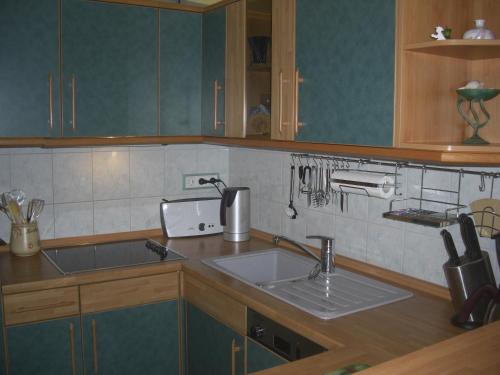 eine Küche mit einer Spüle und einer Arbeitsplatte in der Unterkunft Ferienwohnung am Gespensterwald in Ostseebad Nienhagen