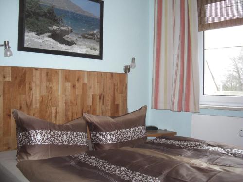 ein Schlafzimmer mit einem Bett mit einem Kopfteil aus Holz in der Unterkunft Ferienwohnung am Gespensterwald in Ostseebad Nienhagen