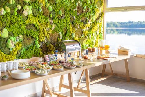 stół z jedzeniem przed zieloną ścianą w obiekcie Forest House Augustów w mieście Augustów
