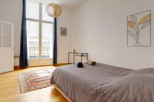 une chambre avec un lit et une grande fenêtre dans l'établissement *Appart 2 chambres, Hypercentre, Emplacement N°1*, à Montpellier