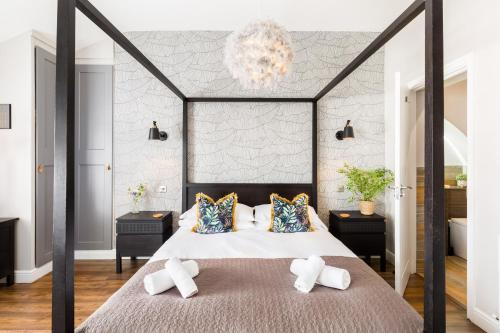 a bedroom with a large bed with pillows and a chandelier at The Shirt Factory Apartments in Warrington