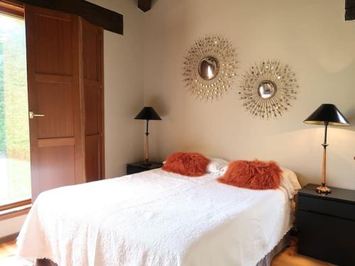 una camera con un letto bianco e due specchi sul muro di LA CASUCA a Silió
