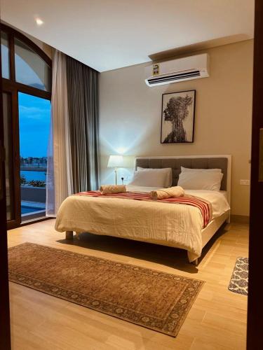 a bedroom with a large bed and a large window at Hawana Lagoon Private villa with private pool in Salalah