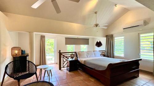 a bedroom with a bed and a table and chairs at Quill Gardens Boutique Hotel in Oranjestad