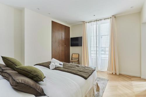 une chambre avec un grand lit et une grande fenêtre dans l'établissement Apartment Champs Elysée bu Studio prestige, à Paris