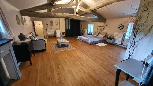 Großes Zimmer mit einem Bett und einem Wohnzimmer. in der Unterkunft Chez Martine in Hanc