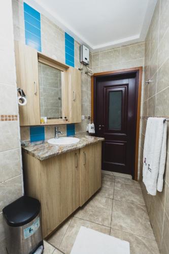 a bathroom with a sink and a black door at Bays Lodge, Accra in Accra