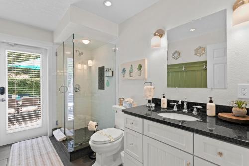 a bathroom with a toilet and a sink and a shower at Saltwater & Sun Pool / Fire Pit / Family Arcade in Tampa