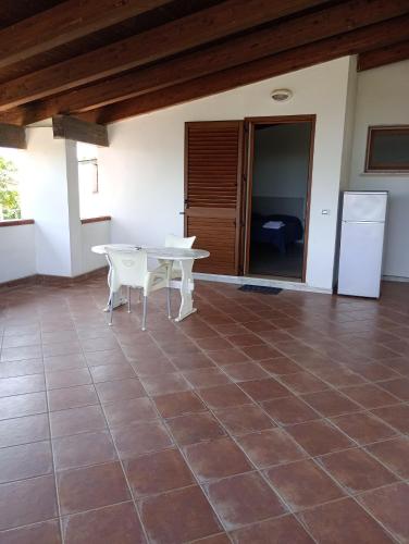 a room with a white table and a white refrigerator at Barrumbas in Santa Lucia