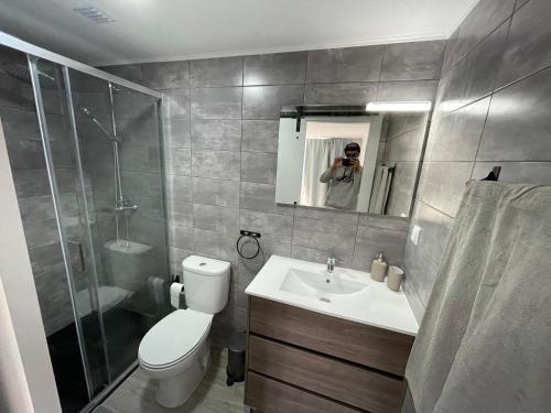une personne prenant une photo d'une salle de bains dans l'établissement Castelo de Bode - Lake House, A Casa do Avô, à Levegada