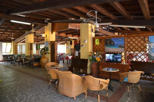restauracja ze stołami i krzesłami w pokoju w obiekcie Campeggio Villaggio Sos Flores w mieście Tortolì