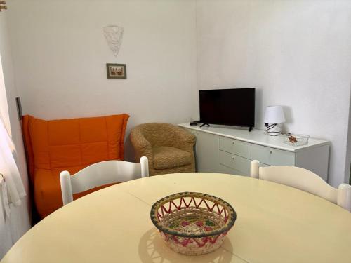 a room with a table and chairs and a television at Tramonto, Rena Majore in Rena Majore