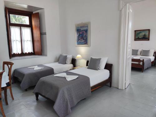 a room with two beds and a couch and a chair at Achilleas Apartment in Hydra